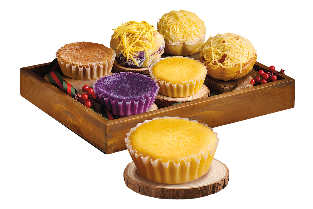 Assorted mamons and ensaimadas on a wooden tray with a white background