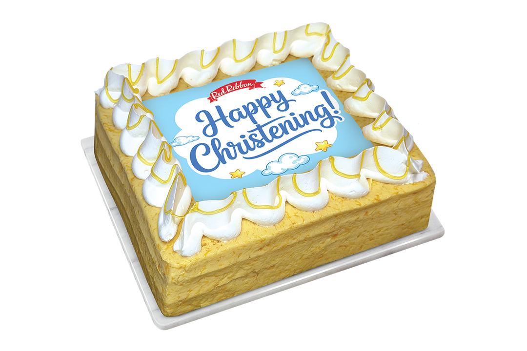 A square mango cake with a border of white piped frosting drizzled with yellow sauce. The center features a square light blue topper displaying the Red Ribbon logo, the message "Happy Christening!" in blue script, and illustrations of small clouds and stars.